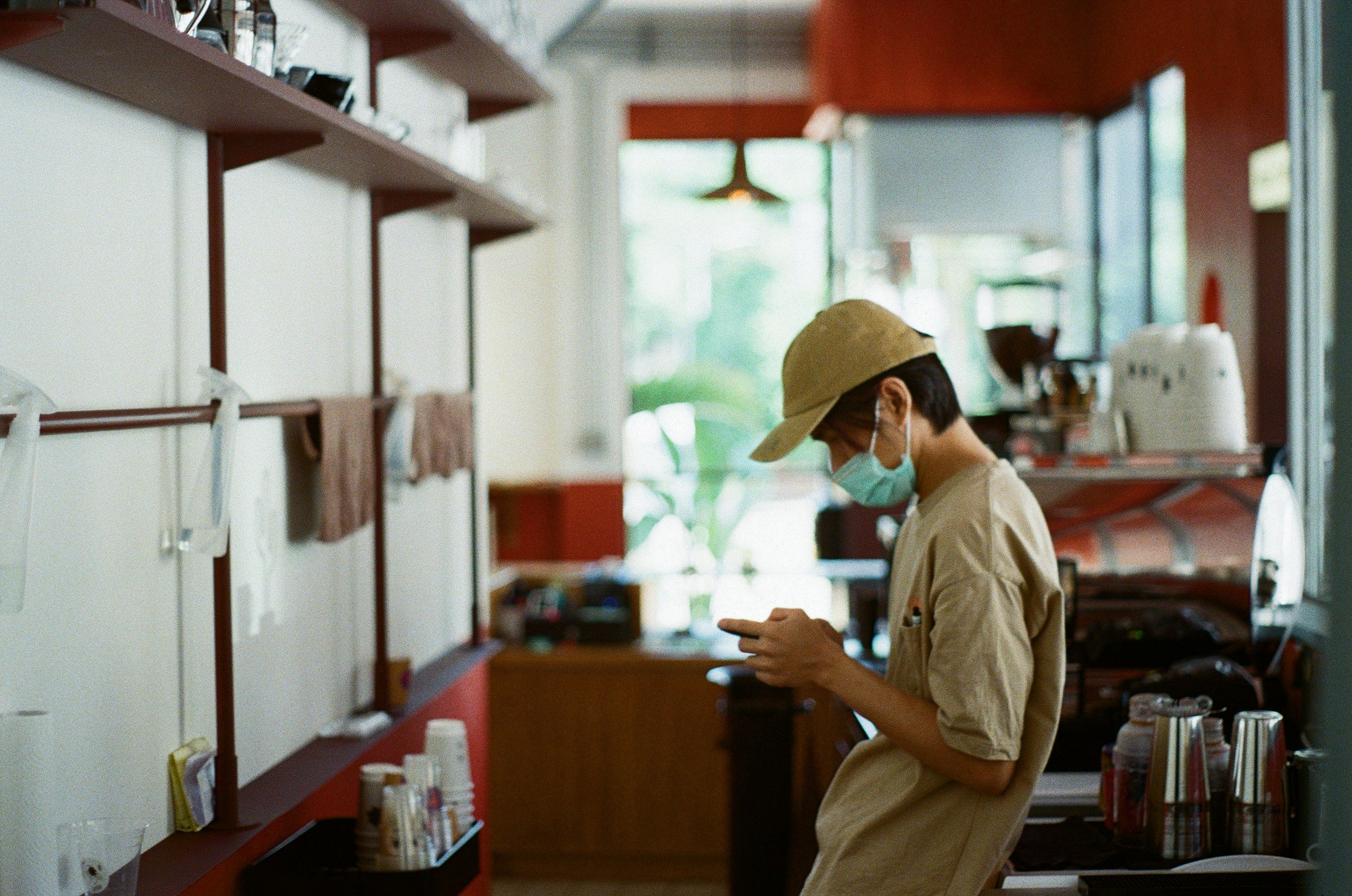 man in white shirt and brown hat standing near brown wooden table